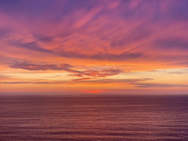 Orange and purple sunset over open water